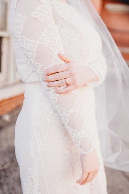 brides wedding dress up close with her wedding ring and veil