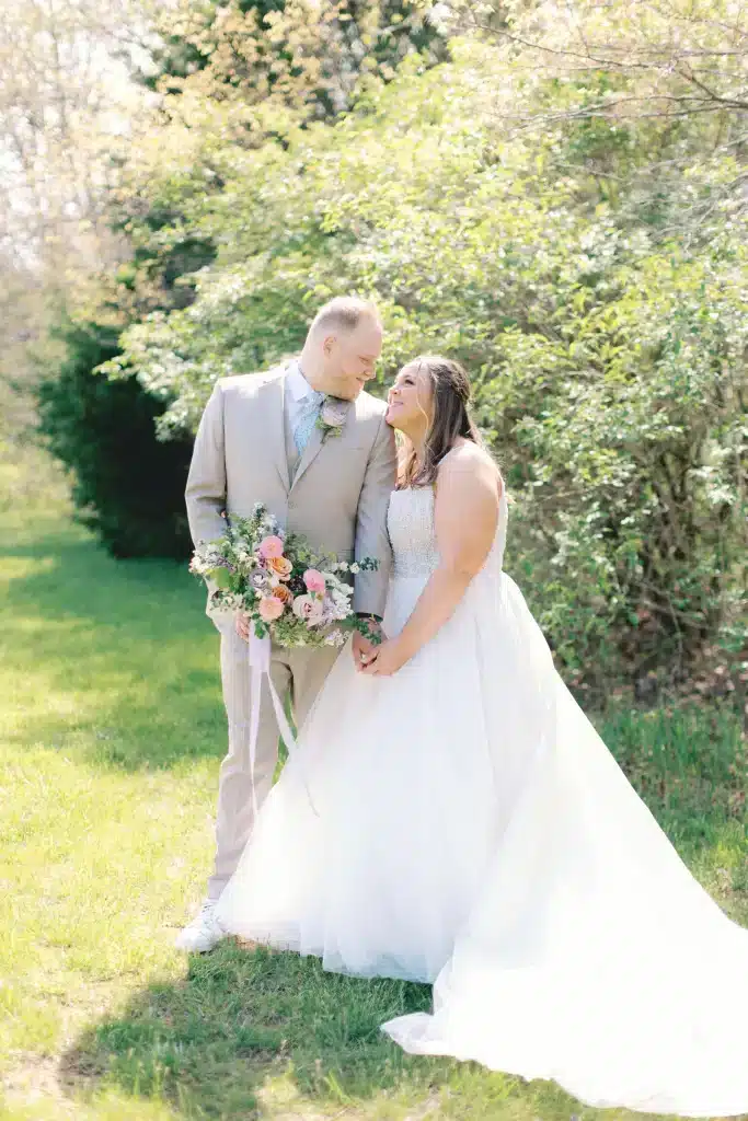 Bride With Bustle Posing For Wedding Photo With Groom In Outdoor Garden