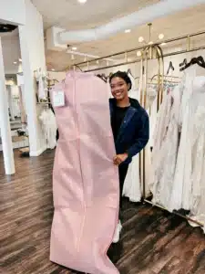 Bride Holding Ready Wedding Dress In Customized Pink Sophia S Garment Bag