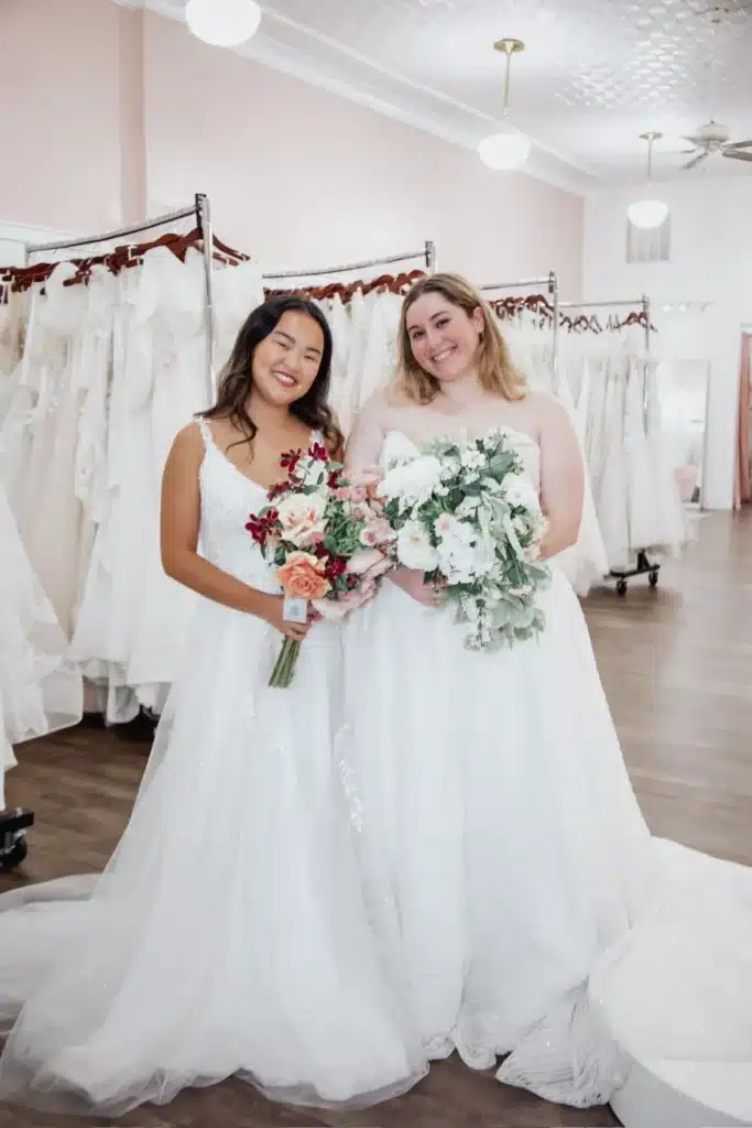 Two Brides Holding Bouquets While Trying On Discount Wedding Dresses In Columbus Indiana
