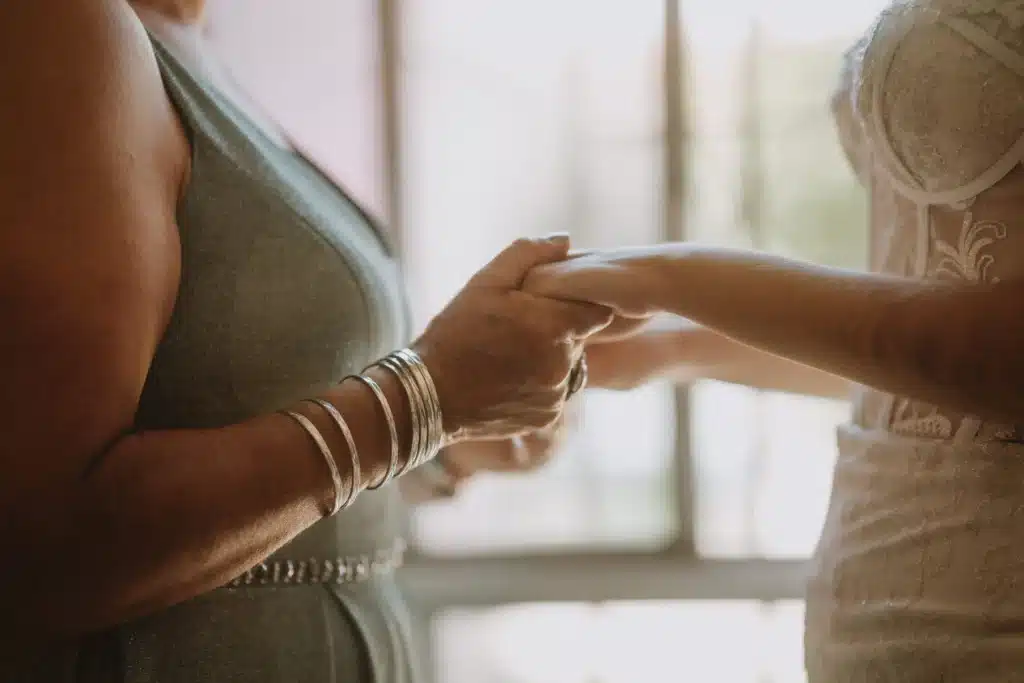 Close Up Of Mother And Bride Holding Hands On Day Of Wedding