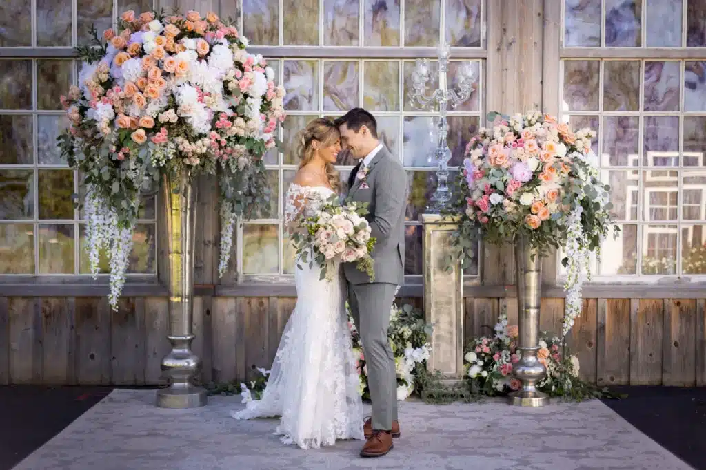 Bride And Groom On Wedding Day Posing In Front Of Decor