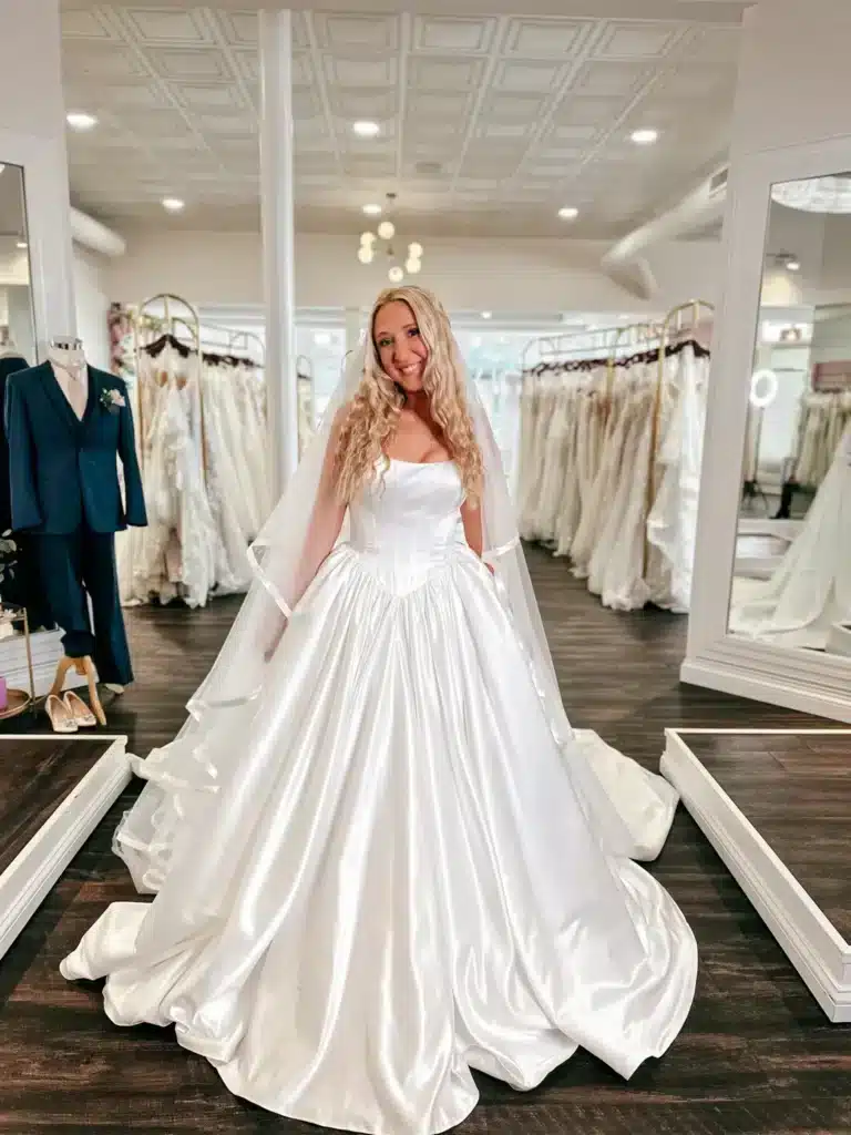 Blonde Bride In Satin Basque Waist Wedding Dress With Veil