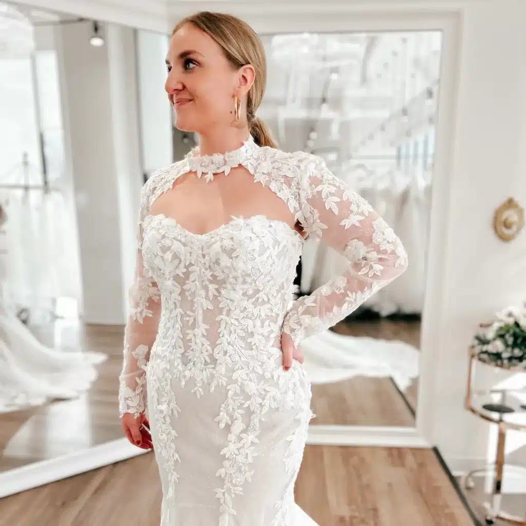 Close Up Of Bride Wearing Lace Fit And Flare Wedding Dress With Cutout Lace Long Sleeves