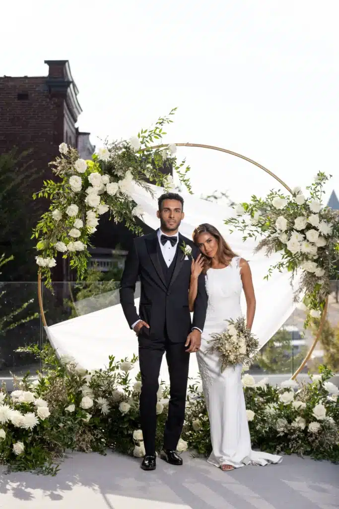 Couple On Wedding Day Standing In Front Of Decor Outside