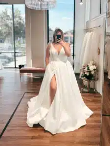Women Posing In Front Of Mirror Trying On Wedding Dress